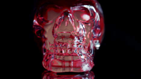 Red-and-blue-skull-face-illuminated-on-black-background,-dolly-shot