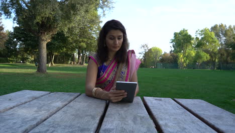 Young-Woman-Using-Tablet-Outdoors-Sunny-Day