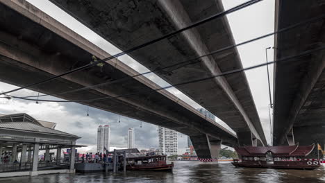 Ferries-coming-and-going-below-Taksin-Bridge,-Bangkok,-Thailand