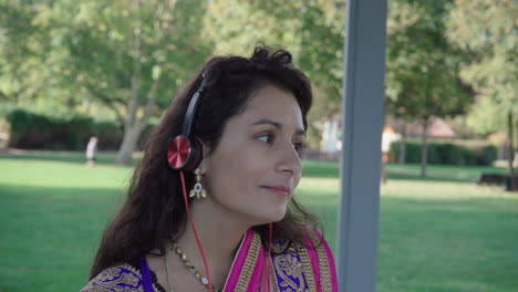 Gorgeous-lady-in-sari-listening-music-in-headphones