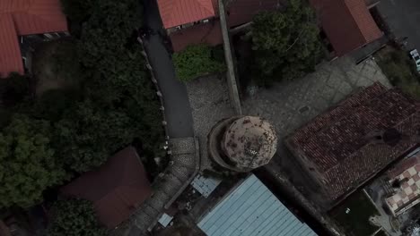 A-drone-shot-of-coming-down-to-zoom-in-on-flowers-growing-on-the-top-of-the-church-in-signagi