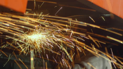 Industry-worker-files-metal-parts-with-a-circular-saw,-generating-spectacular-sparks