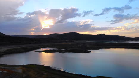 Wide-pass-over-dried-up,-drought-stricken-Irvine-Lake-reservoir-in-Southern-California-with-aerial-drone-4k-at-beautiful-sunset