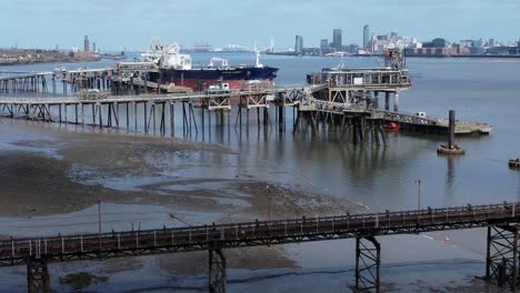Crude-oil-tanker-ship-loading-at-refinery-harbour-terminal-pier-aerial-view-dolly-right