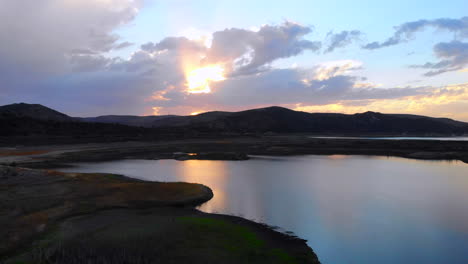 Wunderschöner-Sonnenuntergang,-Rückzug-Der-Luftdrohne-über-Dem-Stausee-Des-Irvine-Sees,-Der-Aufgrund-Der-Dürre-Sehr-Niedrig-Ist