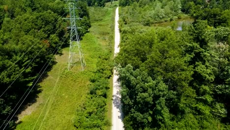 Drone-footage-of-a-rural-trail-and-trees,-and-some-small-ponds-as-well