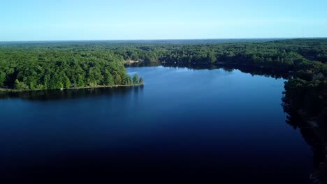 Outdoor-lake-drone-video-clip,-rising-and-sweeping-left-to-right-on-a-sunny-summer-day