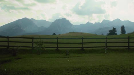 Green-mountain-meadow-landscape-with-mountains-in-the-background