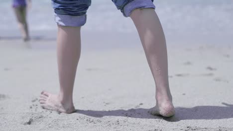 a-slow-motion-clip-of-a-beautiful-young-woman's-legs-walking-on-a-sandy-beach-in-the-summer