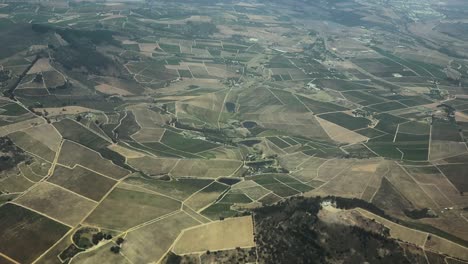 Aerial-shot-of-some-beautiful-green-rolling-hills-covered-with-farms-and-agriculture
