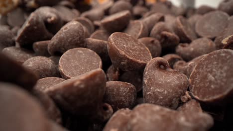 Chocolate-chip-tower-with-cookie-pieces-and-chocolate-chips-falling-macro-close-up-pull-away-4k-food-product-video