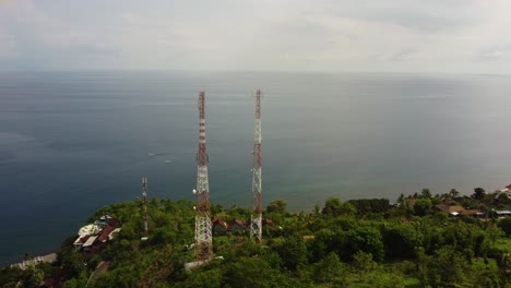 5g-telecom-tower-data-smartphone-gsm-internet-wireless-cliff-over-the-blue-ocean-seascape,-aerial-footage