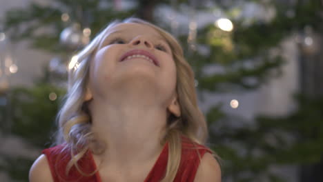 Close-face-portrait-of-Happy-Five-year-girl-by-the-decorated-Christmas-tree