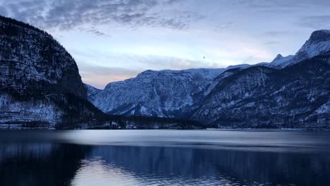 Timelapse-of-Lake-Hallstatt-at-Sunrise-with-beautiful-colors-and-moving-clouds-at-the-top-of-the-mountain