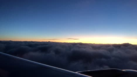 Flying-with-a-plane-above-clouds-for-travel-and-vacation-during-sunset