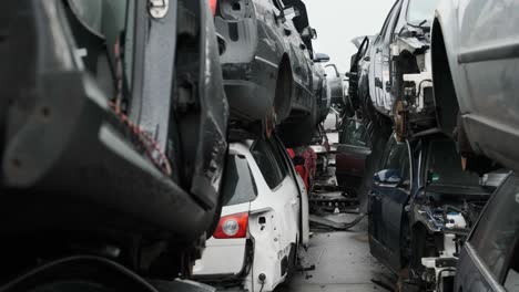 Scrapyard-scene,-walking-through-a-tunnel-of-destroyed-cars