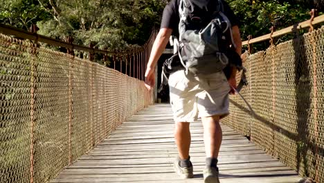 Backpacker-walking-across-suspenion-bridge-.mp4