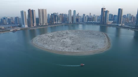 4k:-Sharjah-Desde-Arriba,-Vista-Aérea-Del-Lago-Al-Khan-De-Sharjah-Y-La-Isla-Al-Khan-Con-Rascacielos-Modernos,-Negocios-De-Turismo-De-Viajes-En-Los-Emiratos-árabes-Unidos