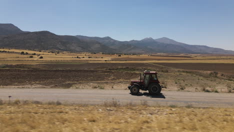 Tractor-Conduciendo-Por-Las-Carreteras-De-Los-Campos-De-Agricultores-Y-Las-Montañas