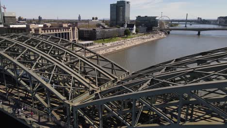FlyOver-Hohenzollern-Bridge,-Train-crosses-Rhine-River-Cologne-Germany