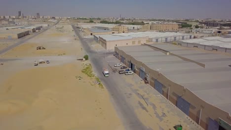 A-truck-driving-by-warehouses-in-the-desert-with-large-garage-gate-doors