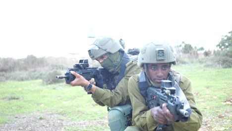 Enthüllung-Zweier-Infanteristen-Der-Israelischen-Armee,-Die-Eine-Kniende-Position-Halten-Und-Mit-Maschinengewehren-Auf-Das-Schlachtfeld-Zielen