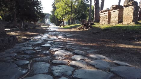 Roman-road-covered-with-stone-blocks-at-the-entrance-of-Ostia-Antica,-a-world-famous-archeological-site