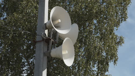 A-set-of-white-loudspeakers-attached-to-a-pole