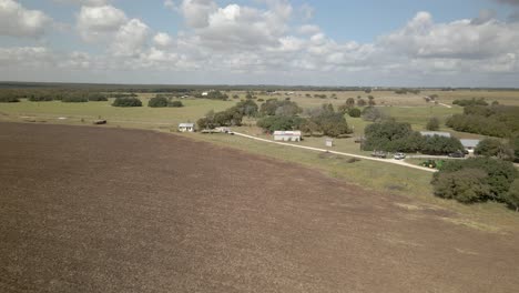 Farmland-flyover-in-western-Texas-on-a-sunny-day-with-some-clouds-about