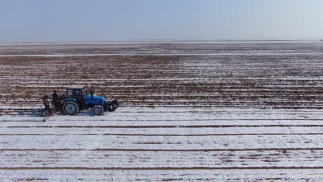 Farming-Tractor-Plowing-Snowy-Field-During-Winter-In-Ukraine