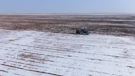 Landwirtschaftlicher-Traktor,-Der-Im-Winter-In-Der-Ukraine-Durch-Das-Ackerland-Sät