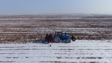 Agricultural-Tractor-Tilling-The-Farmland-With-Snow-In-Ukraine