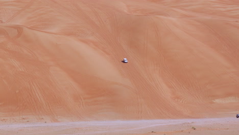4WD-Vehicle-Goes-Off-road-In-Huge-Desert-Sand-Dunes-In-Sharjah,-United-Arab-Emirates---wide-shot