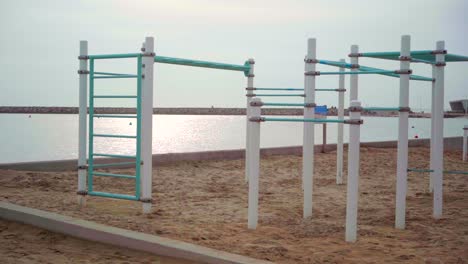 Empty-outdoor-gym-on-the-beach,-deserted-during-the-Covid-19-pandemic-lockdown,-on-a-cloudy-day