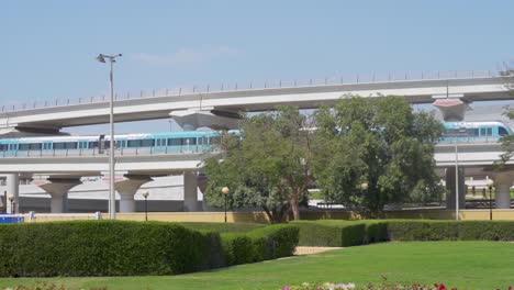 Dubai-Metro-Parked-At-Elevated-Viaduct-Of-Al-Rashidiya-Metro-Station-From-Rashidiya-Park-In-Dubai,-UAE