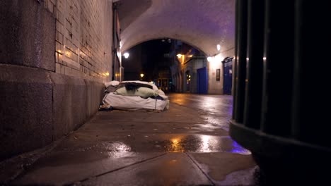 Obdachlose-Bettmatratze-In-Einem-Tunnel-In-London-Nachts,-An-Einem-Regnerischen-Tag,-Pfützen-Auf-Dem-Boden,-Armutsprobleme-In-Städten