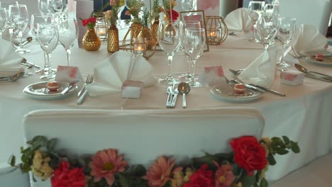 Wedding-table-decorated-with-flowers-and-shinning-tableware,-motion-shot