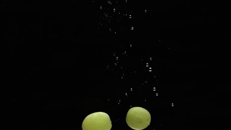 Fast-drowning-grapes-with-air-bubbles-isolated-on-black-background
