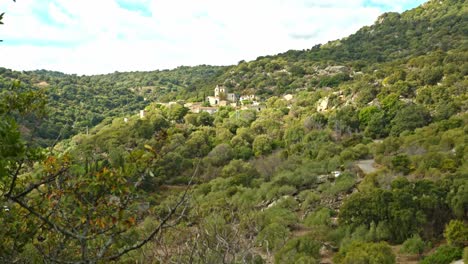 Beautiful-old-Italian-village-surrounded-by-dense-forest-in-Sardinia-island,-tilting-up-view