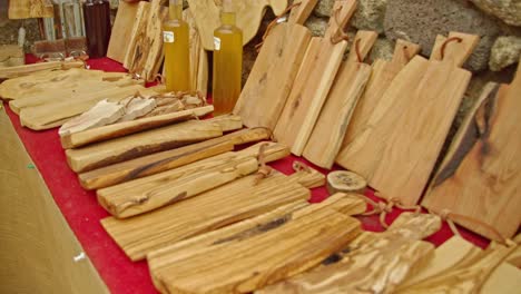 Display-of-beautiful-wooden-cutting-boards-in-local-market,-dolly-backward-shot