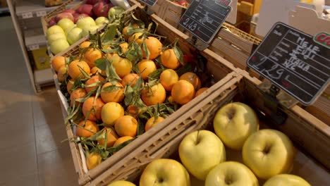 Naranjas-Frescas-Una-Manzana-En-El-Mercado-Local-En-Exhibición,-Moviéndose-Sobre-Tiro