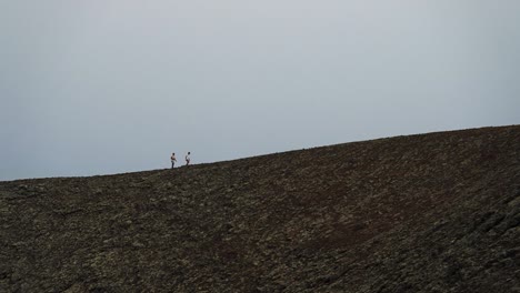 Dos-Hombres-Caminando-En-Una-Montaña-De-Volcán-En-Cámara-Lenta