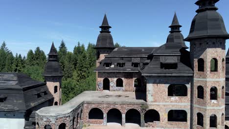 Unfinished-castle-building-of-Lapalice-in-Poland,-aerial-fly-away-shot