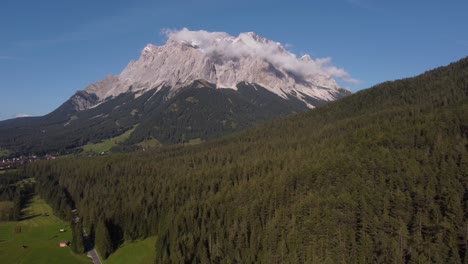Absteigende-Drohnenaufnahme-Des-Spektakulären-Matterhorns,-Gefilmt-An-Einem-Sonnigen-Tag-Mit-Einer-Drohne,-Bis-Der-Berg-Im-Vordergrund-Mit-Bäumen-Bedeckt-Ist