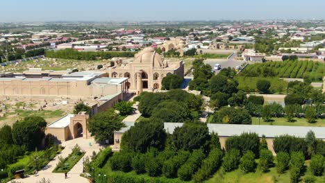 Turistas-En-El-Complejo-Memorial-Baha-ud-din-Naqshband-Bokhari-Con-árboles-Verdes-En-El-Jardín-En-Bukhara,-Uzbekistán