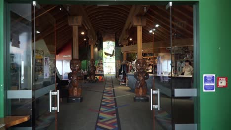 SLOWMO---Inside-Arataki-Visitor-Centre-with-Maori-sculptures-and-souvenirs,-New-Zealand