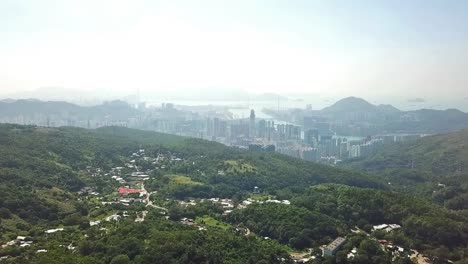 Aerial-shot,-flying-from-the-jungle-into-the-busy-city-in-Hong-Kong