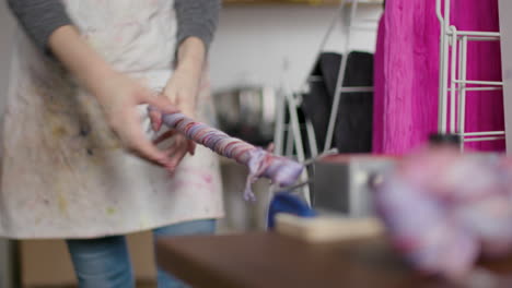 Woman-putting-yarn-onto-a-mechanical-skein-roller-and-rolling-it-up