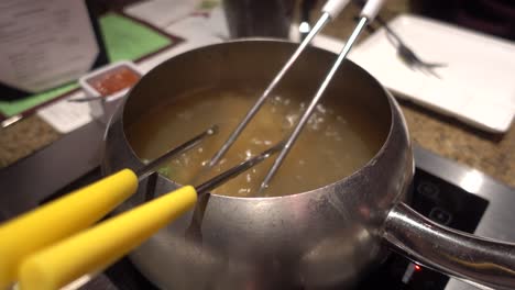 Fondue-pot-boiling-with-hot-oil-and-food-cooking-inside
