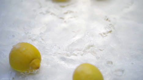 Slomo-Von-Zitronen,-Die-Auf-Weißem-Hintergrund-Ins-Wasser-Fallen